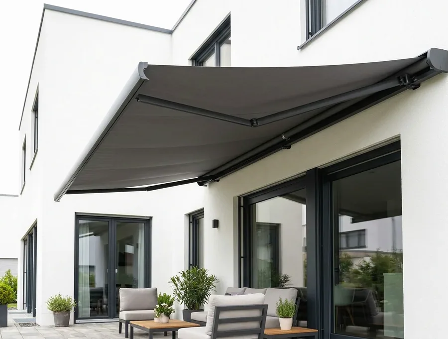 A folding-arm awning extended on its arms over a patio seating area